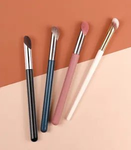 Close-up detail of cosmetic makeup brushes with soft synthetic fibers and smooth wooden handles.