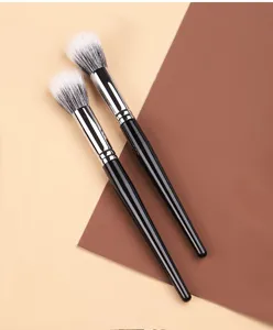 Vue détaillée de deux pinceaux estompeurs de maquillage aux poils doux et manches noirs.