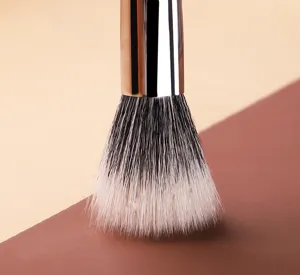 Gros plan détaillé des poils de maquillage et de la ferrule métallique, texture douce.