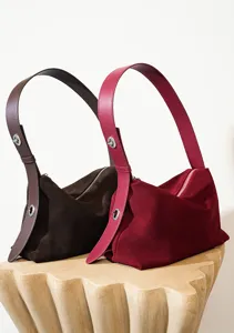 Vista detallada de bolso de hombro de ante para mujer en marrón oscuro y rojo con cremalleras.
