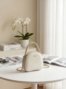 Minimalistische Damen Ledertasche, elegantes Kuppeldesign mit Tragegriff und Goldkettenriemen.