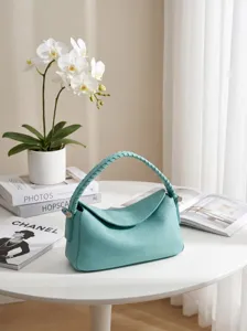 Elegante borsa a tracolla in pelle turchese con manico intrecciato e chiusura a patta.