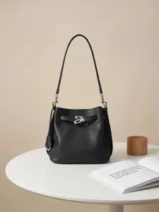 Borsa a secchiello in vera pelle con motivo litchi e chiusura metallica elegante.