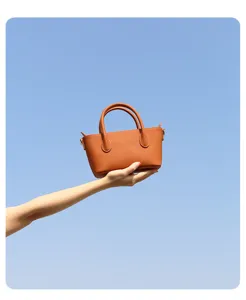 Gedetailleerd overzicht van minimalistische bruine lederen handtas met elegante textuur en stijl.
