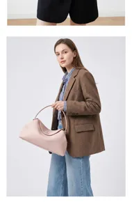 Vista detallada del bolso de mano de cuero genuino rosa llevado por modelo, textura elegante.