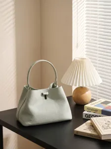 Borsa secchiello minimalista in pelle con manico e chiusura metallica chic per uso quotidiano.