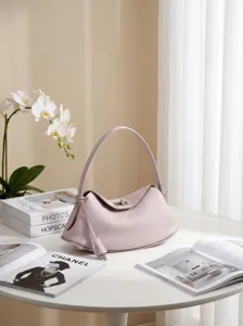 Elegante rosafarbene Leder-Umhängetasche mit Griff, minimalistisches Premium-Design für Damen.