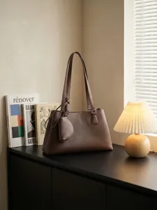 Elegante braune Damentasche aus Leder, modernes minimalistisches Design mit Griff oben.