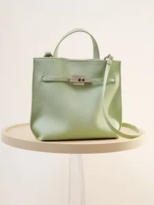 Hellgrüne Umhängetasche aus echtem Leder, elegante minimalistische Form mit Metallverschluss.