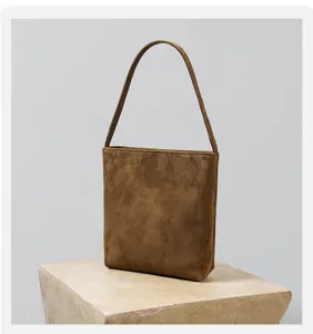 Braune Wildleder Textur Detail der Vintage Pendler Tasche, zeigt feine handwerkliche Arbeit.