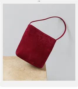 Burgunderrote Wildleder Schultertasche Detail mit weicher Textur und minimalistischem Riemen.