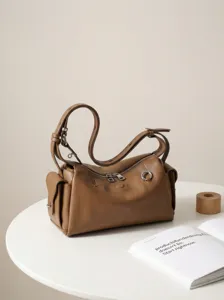 Stijlvolle bruine lederen schoudertas voor dames, casual crossbody ontwerp met metalen accenten.