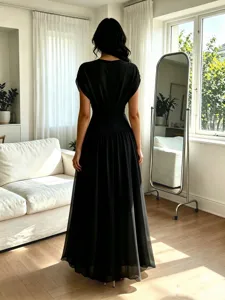 Détails de la robe de soirée élégante en mousseline noire avec ourlet fluide et ajusté.