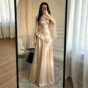Élégante robe de soirée longue en satin champagne sans bretelles avec manches transparentes.