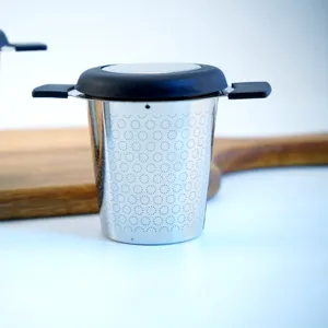 Stainless steel tea infuser with fine mesh, black handle and lid for home and outdoor use.
