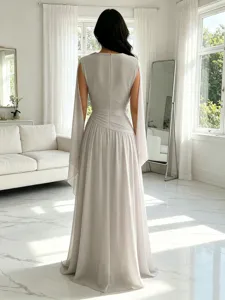Detalle de vista trasera de elegante vestido de noche largo de gasa con mangas de capa.