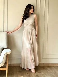 Elegante vestido largo plisado en color beige con cuello halter chic y diseño de cintura ajustada.