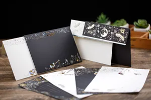 Detailansicht von Briefpapier mit Goldprägung und eleganten Gitarren- und Federmustern.