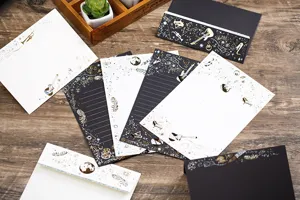 Detailansicht des bronzierten Briefpapier-Sets mit goldenen Gitarren- und Federmotiven.