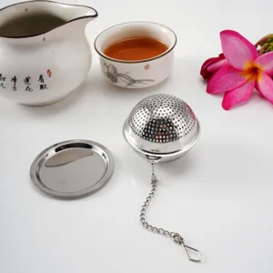 Stainless steel tea infuser ball with chain and drip tray for loose leaf tea brewing.