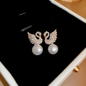 Exquisite swan crystal pearl earrings fine detail shot, elegant gold tone design.