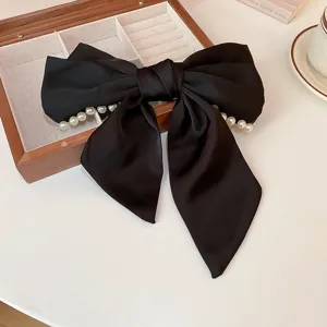 Horquilla con lazo de terciopelo negro y perlas, elegante detalle de pinza francés.