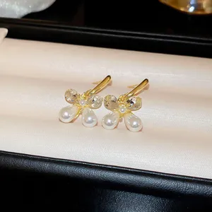 Detail shot of exquisite gold pearl crystal drop earrings on velvet jewelry box display.