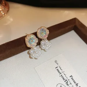 Close-up detail of iridescent flower pearl drop earrings, elegant retro jewelry accessory.