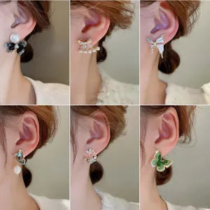 Detailed view of elegant zircon pearl butterfly ear studs, stylish silver needle fashion jewelry.