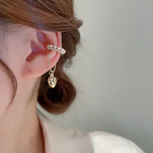 Detail view of dainty pearl and rhinestone tassel ear cuff, non-piercing design with heart charm.