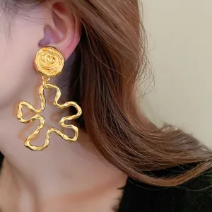Close-up detail shot of exquisite gold-plated abstract flower earrings, elegant design.