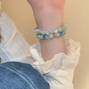 Detail view of a stylish double-layer crystal beaded bracelet featuring blue and green stones.