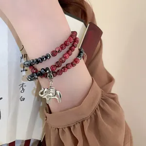 Detailed view of a multi-layer crystal beaded bracelet featuring a cute silver elephant charm.