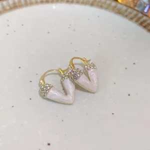 Close-up detail shot of exquisite rhinestone inlaid white V-shaped metal earrings accessory