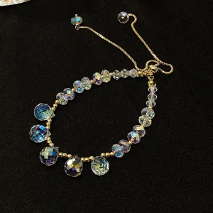 Detail shot of crystal adjustable bracelet, sparkling faceted beads and gold chain details.