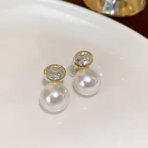 Detailed close-up view of elegant French style pearl and crystal stud earrings with shiny finish.