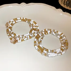 Chic multi-layer beaded bracelet with white and gold beads and cute butterfly charms.