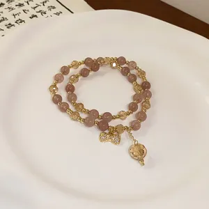 Detail view of the double-layer crystal beaded bracelet with cute bow charm and pendant.