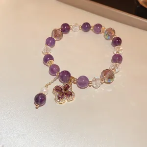Purple crystal beaded bracelet detail showing exquisite four leaf clover pendant and delicate gold chain.
