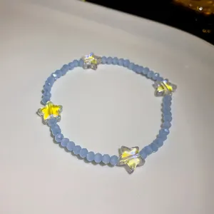 Close-up of a sweet light blue beaded bracelet featuring vibrant yellow star charms for women.
