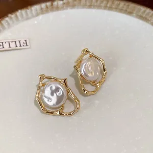 Gold-plated irregular pearl drop earrings detail shot, showcasing chic niche fashion design.