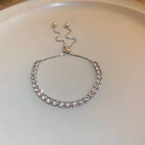 Close-up detail of sparkling crystal tennis bracelet with adjustable slider chain design.