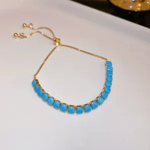 Adjustable golden slider bracelet featuring vibrant turquoise blue round crystal beads.