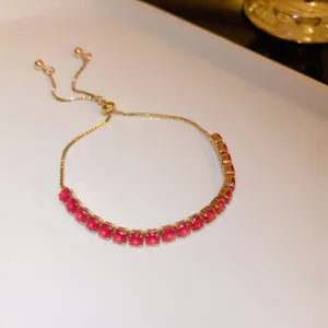 Elegant red crystal slider bracelet with gold-tone finish, chic adjustable jewelry piece.