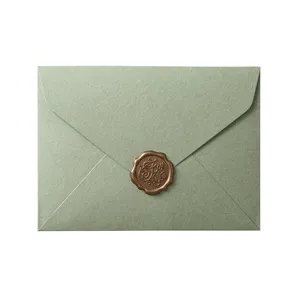 Close up detail of avocado green envelope with elegant bronze wax seal for romantic invitations.