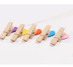 Wooden clips detail close-up showing colorful heart wooden pins arranged neatly on white paper.