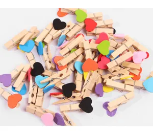 Wooden clothespins with colorful hearts, close-up detail shot of cute craft clips for photo display.