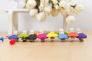 Close-up detail of colorful heart wooden clips arranged on wooden surface for photo wall decor.