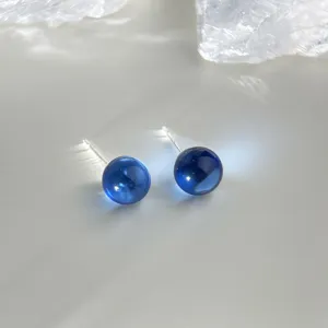 Stunning translucent blue crystal ball stud earrings, delicate close-up detail shot for women.