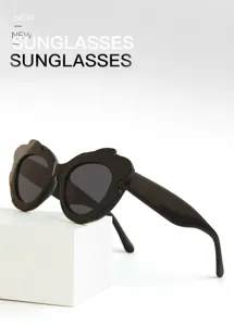 Detailed close-up view of stylish black sunglasses with unique wavy frames on a clean white display.